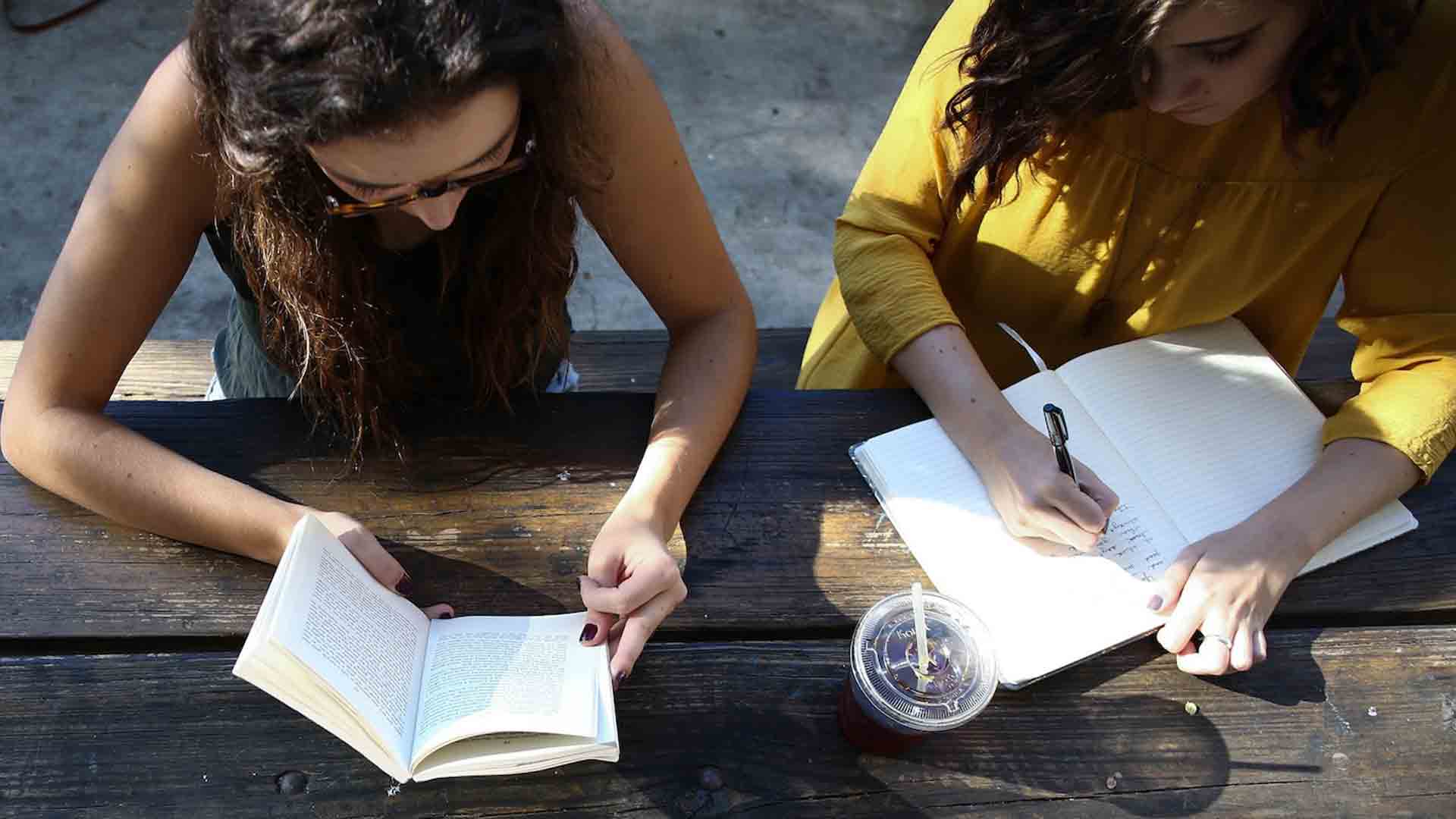 Friends studying yoga philosophy books for Yoga Teacher Training