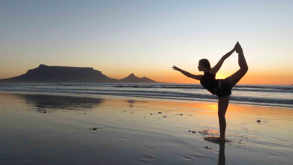 yoga at sunset in cape town, south africa - one of the best yoga travel destinations in the world