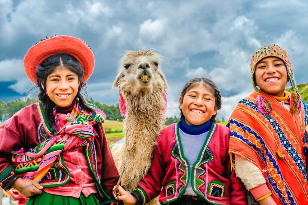Indigenous people in colourful clothes with a lama in Peru