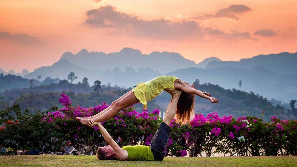 Young couple doing opening the heart chakra in couples yoga